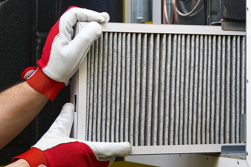 Dirty air filter being removed from a homes unit.