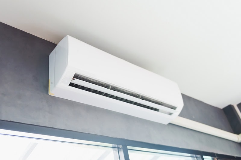 Why Are They Called Ductless Mini Splits? Cool air conditioner swing system on wall in room.