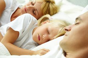 Portrait of calm family sleeping with focus on cute child