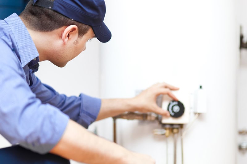 Technician repairing a hot-water heater.